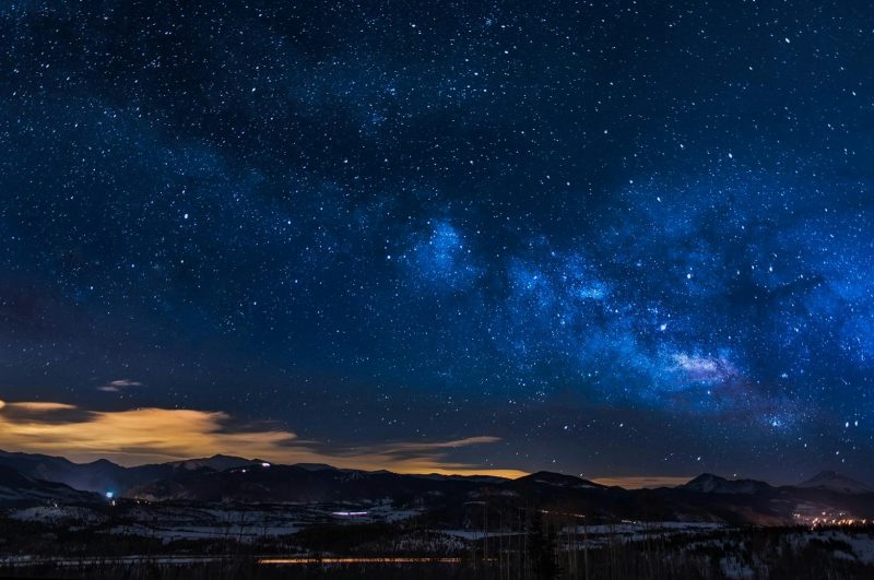 A breathtaking view of the Milky Way galaxy illuminating the night sky over mountains.