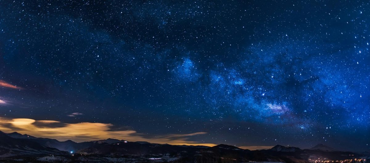 A breathtaking view of the Milky Way galaxy illuminating the night sky over mountains.